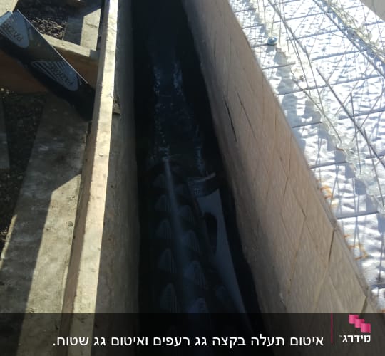 חומר איטום שחור מונח בתעלה בין קירות